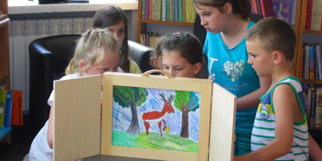 biblioteka_wakacje_1 dzieci czytają i przedstawiają swoje karty kamishiabi