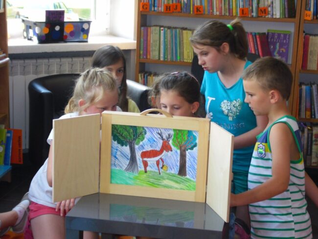 biblioteka_wakacje_1 dzieci czytają i przedstawiają swoje karty kamishiabi