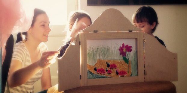 dzieci z tyłu parawanu (butai) czytają steotrzoną przez siebie historię